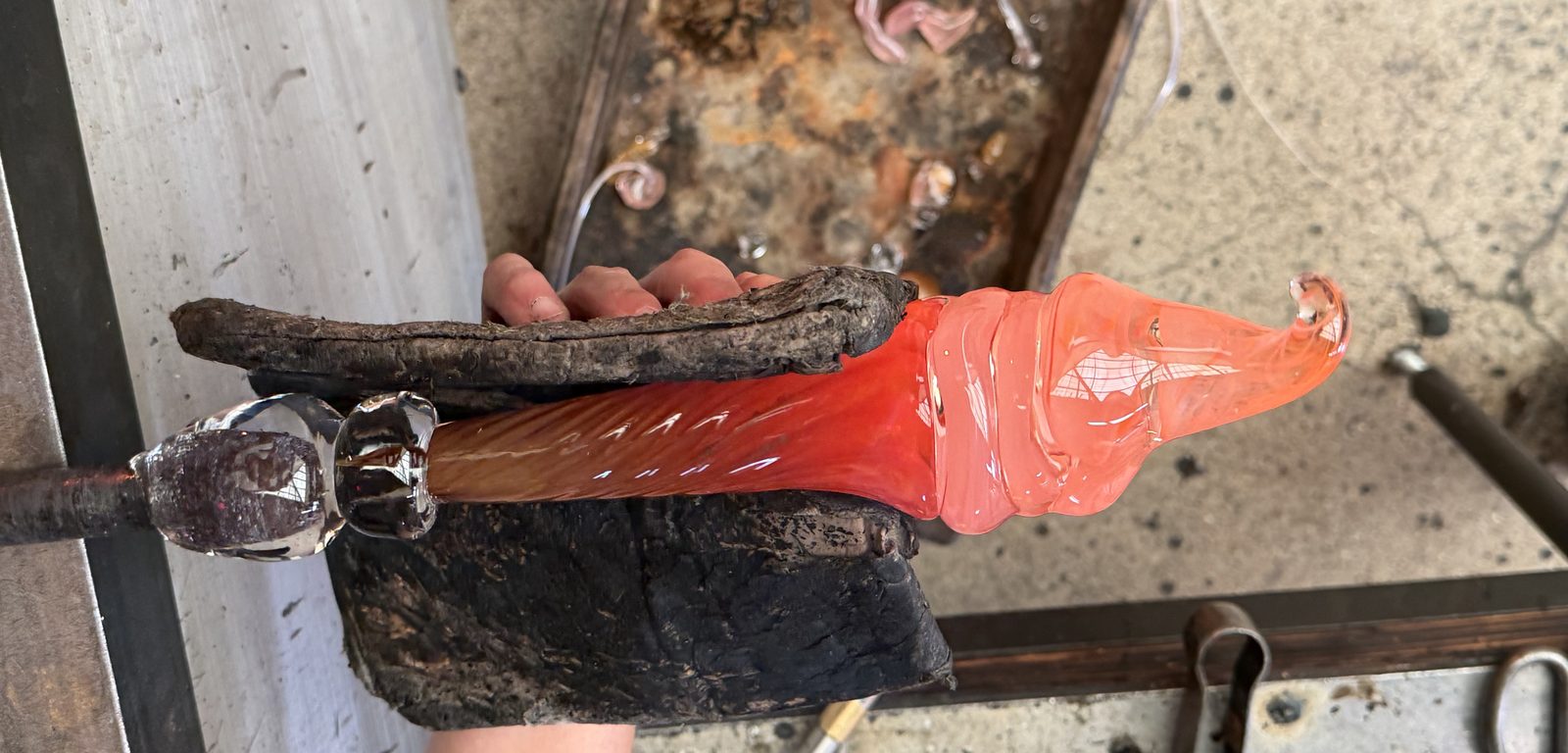 Molten glass being shaped on a punty during a live MELT glassmaking demonstration