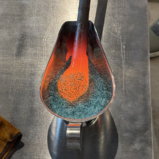 Close-up of a finished blue frit glass bowl