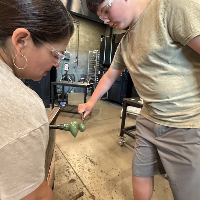 Close-up of pinching and shaping hot glass